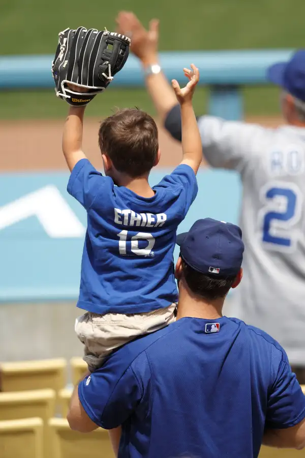 A young fan holds up a glove in hopes of catching a baseball as his father holds him on his shoulders during the Los Angeles Dodgers Father's Day game against the Houston Astros on June 19, 2011 at Dodger Stadium in Los Angeles, California.