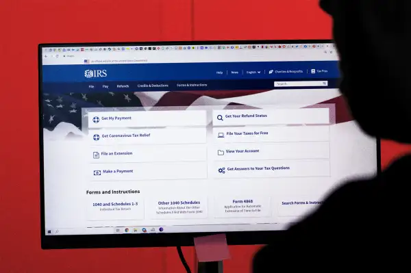 Close-up of a person using a computer, with the IRS website on it.